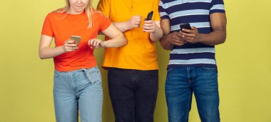 Bir grup arkadaş cep telefonu kullanıyor. Gençlerin yeni teknoloji eğilimlerine olan bağımlılığı. Kapat..