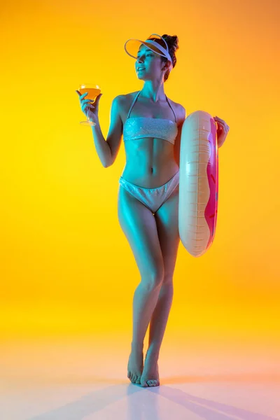 Modeporträt eines verführerischen Mädchens in stilvoller Badebekleidung, das vor leuchtend gelbem Hintergrund posiert. Sommerzeit, Badesaison — Stockfoto