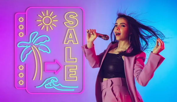 Blanke zangeres portret geïsoleerd op gradiënt studio achtergrond in neon licht met neon teken — Stockfoto