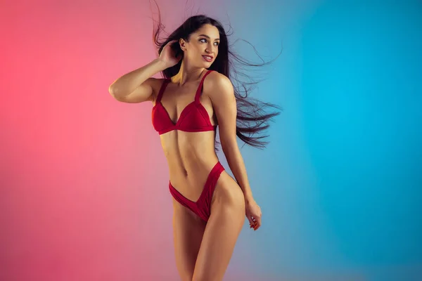 Retrato de moda de jovem em forma e mulher esportiva em trajes de banho elegantes de luxo vermelho no fundo gradiente. Corpo perfeito pronto para o verão . — Fotografia de Stock