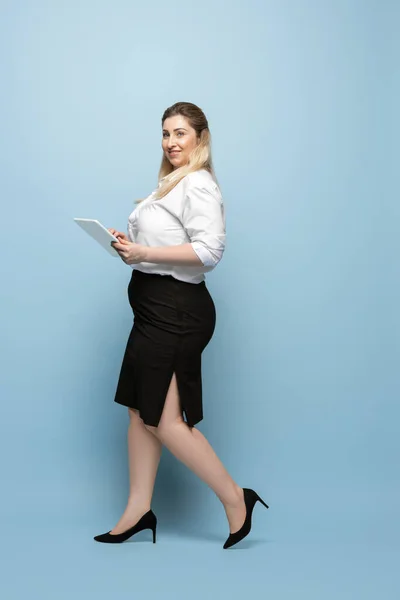 Młoda biała kobieta w stroju biurowym na niebieskim tle. Pozytywny kobiecy charakter. plus size businesswoman — Zdjęcie stockowe