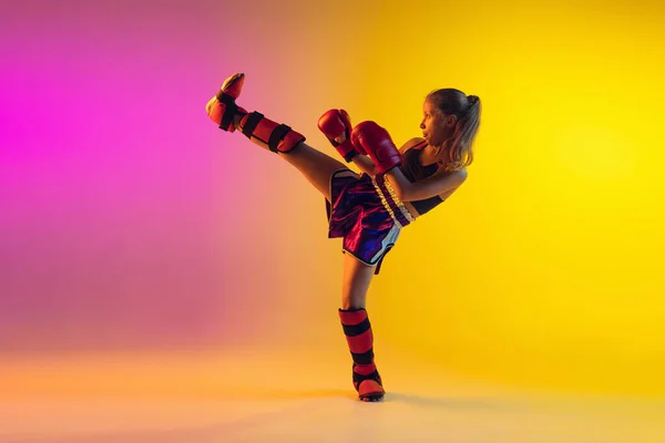 Piccolo allenamento femminile caucasico di kick boxer su fondo sfumato in luce al neon, attivo ed espressivo — Foto Stock