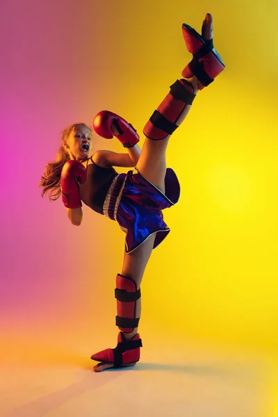 Piccolo allenamento femminile caucasico di kick boxer su fondo sfumato in luce al neon, attivo ed espressivo — Foto Stock