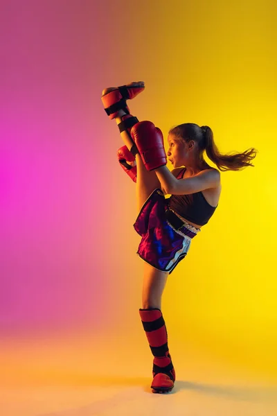 Piccolo allenamento femminile caucasico di kick boxer su fondo sfumato in luce al neon, attivo ed espressivo — Foto Stock