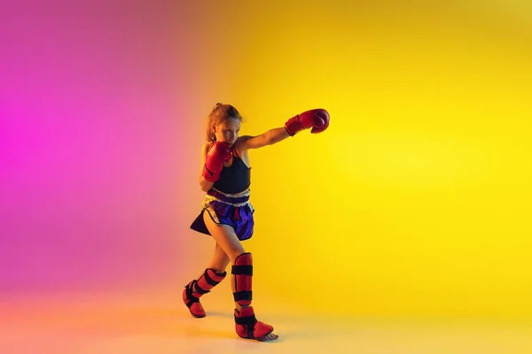 Piccolo allenamento femminile caucasico di kick boxer su fondo sfumato in luce al neon, attivo ed espressivo — Foto Stock