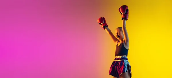 Weinig blanke vrouwelijke kick bokser training op gradiënt achtergrond in neon licht, actief en expressief — Stockfoto
