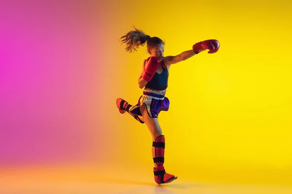 Piccolo allenamento femminile caucasico di kick boxer su fondo sfumato in luce al neon, attivo ed espressivo — Foto Stock