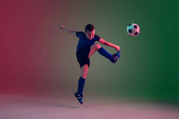 Έφηβος ποδοσφαιριστής ή ποδοσφαιριστής, αγόρι σε κλίση φόντο σε νέον φως - κίνηση, δράση, έννοια δραστηριότητας — Φωτογραφία Αρχείου