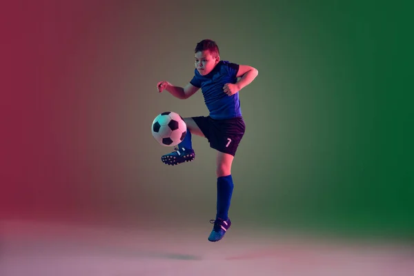 Männlicher Fußball- oder Fußballspieler, Junge auf Gradientenhintergrund im Neonlicht - Bewegung, Aktion, Aktivitätskonzept — Stockfoto