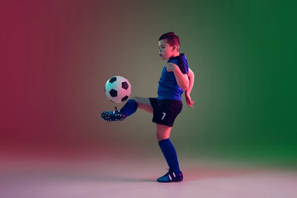 Adolescente futebol masculino ou jogador de futebol, menino em fundo gradiente em luz de néon - movimento, ação, conceito de atividade — Fotografia de Stock