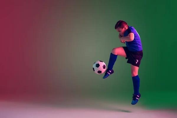 Männlicher Fußball- oder Fußballspieler, Junge auf Gradientenhintergrund im Neonlicht - Bewegung, Aktion, Aktivitätskonzept — Stockfoto