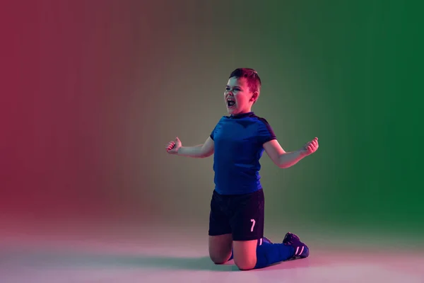 Tiener man voetbal of voetbal speler, jongen op gradiënt achtergrond in neon licht - beweging, actie, activiteit concept — Stockfoto