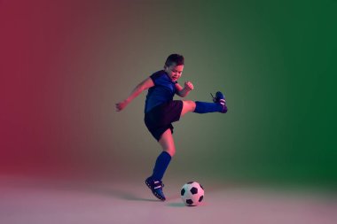 Genç erkek futbolcu ya da futbolcu, neon ışıkta eğimli arka plan çocuğu - hareket, aksiyon, aktivite konsepti
