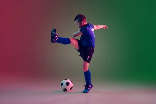 少男足球运动员或足球运动员,具有霓虹灯光运动,动作,运动概念等梯度背景的男孩 — 图库照片