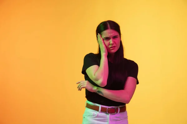 Mulheres brancas jovens retrato em fundo amarelo em luz de néon — Fotografia de Stock