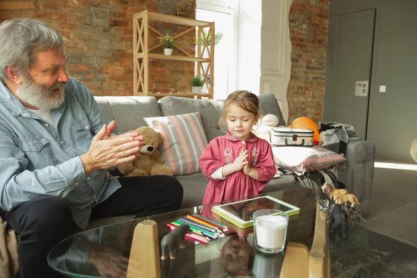 Grandfather and child playing together at home. Happiness, family, relathionship, education concept.