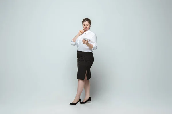 Giovane donna caucasica in abito da ufficio su sfondo grigio. Carattere femminile Bodypositive. più dimensioni donna d'affari — Foto Stock