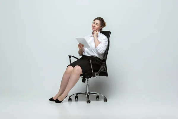 Mujer joven caucásica en traje de oficina sobre fondo gris. Personaje femenino positivo. más tamaño mujer de negocios — Foto de Stock