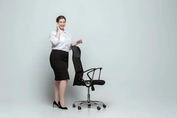 Młoda biała kobieta w stroju biurowym na szarym tle. Pozytywny kobiecy charakter. plus size businesswoman — Zdjęcie stockowe