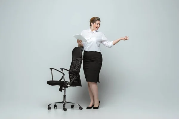 Giovane donna caucasica in abito da ufficio su sfondo grigio. Carattere femminile Bodypositive. più dimensioni donna d'affari — Foto Stock
