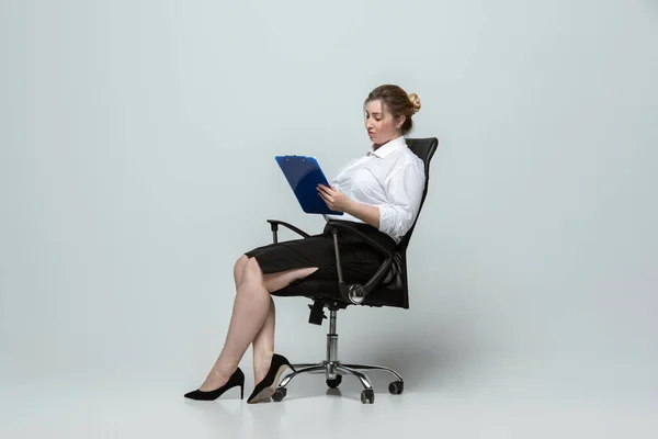 灰色の背景にオフィスの服装で若い白人女性。体に良い女性のキャラクター。プラスサイズのビジネスウーマン — ストック写真