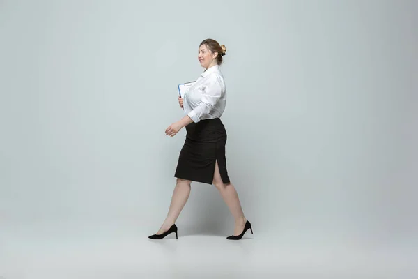 灰色の背景にオフィスの服装で若い白人女性。体に良い女性のキャラクター。プラスサイズのビジネスウーマン — ストック写真