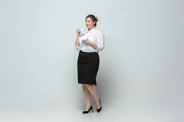 Молода біла жінка в офісному одязі на сірому фоні. Тілесно-позитивний жіночий характер. плюс розмір бізнес-леді — стокове фото