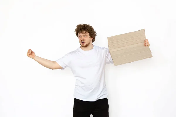 Joven protestando con tablero en blanco, letrero aislado sobre fondo blanco del estudio — Foto de Stock