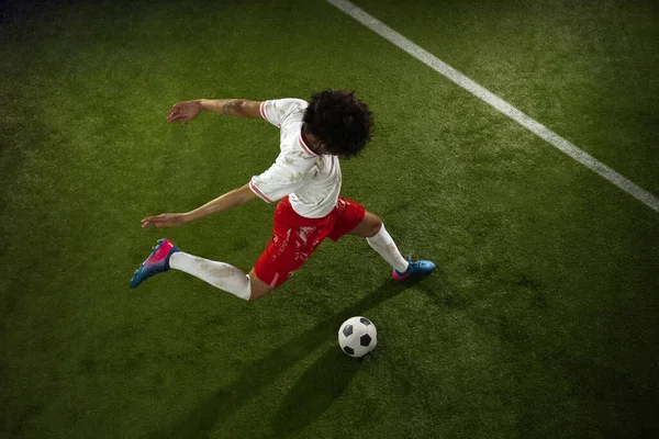 Vista superior del fútbol caucásico o jugador de fútbol sobre fondo verde de hierba en acción y movimiento —  Fotos de Stock