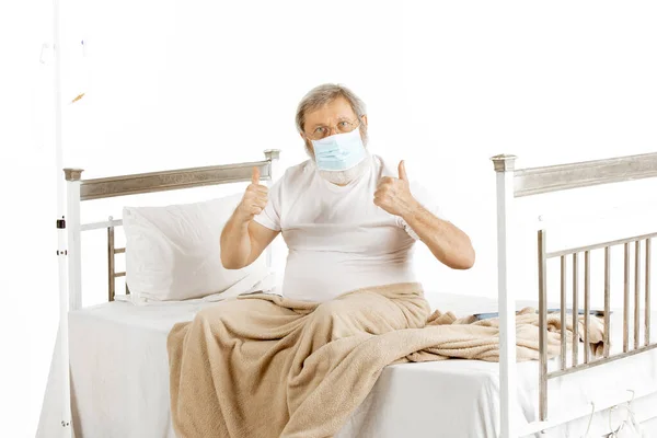 백인에게 고립된 병원 침대에서 회복되고 있는 노인 — 스톡 사진