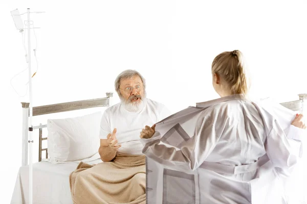 Літній літній чоловік, який відновлюється в лікарняному ліжку ізольовано на білому — стокове фото