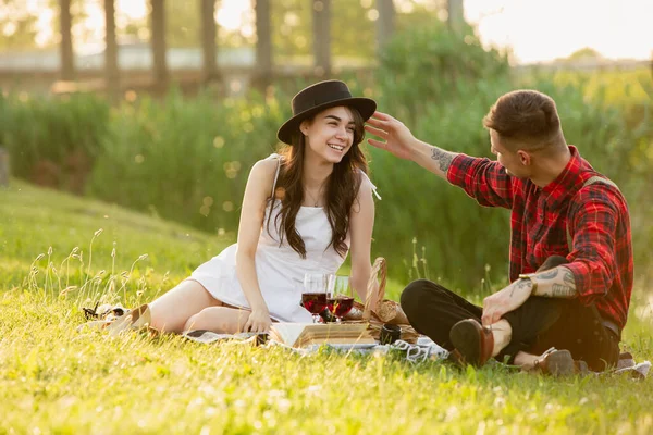 Biała młoda i szczęśliwa para ciesząca się piknikiem w parku w letni dzień — Zdjęcie stockowe
