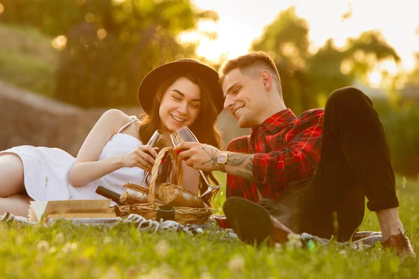 Casal jovem e feliz caucasiano desfrutando de um piquenique no parque no dia de verão — Fotografia de Stock