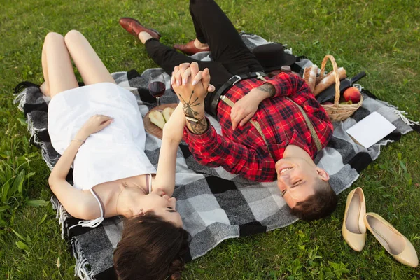 Kaukasisch jong en gelukkig koppel genieten van een picknick in het park op zomerdag — Stockfoto