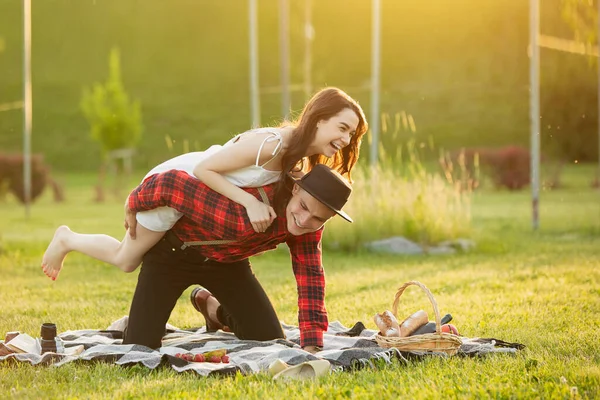 Kaukasisch jong en gelukkig koppel genieten van een picknick in het park op zomerdag — Stockfoto