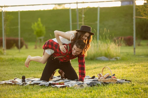 Kaukasisch jong en gelukkig koppel genieten van een picknick in het park op zomerdag — Stockfoto