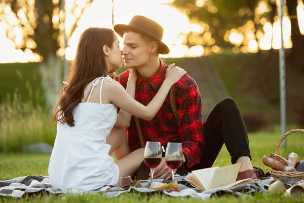 Kaukasiska unga och lyckliga par njuter av en picknick i parken på sommardagen — Stockfoto