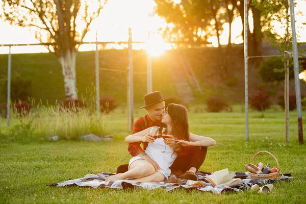 Kaukasiska unga och lyckliga par njuter av en picknick i parken på sommardagen — Stockfoto