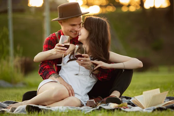 Kaukasiska unga och lyckliga par njuter av en picknick i parken på sommardagen — Stockfoto