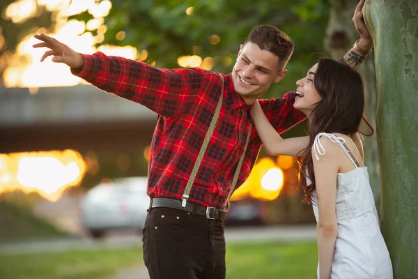 Kaukasiska unga och lyckliga par njuter av en picknick i parken på sommardagen — Stockfoto