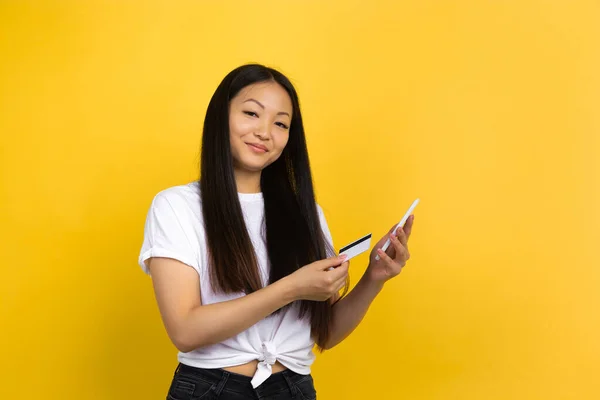 Portrait of young asian woman isolated on yellow studio background — Stock Photo, Image