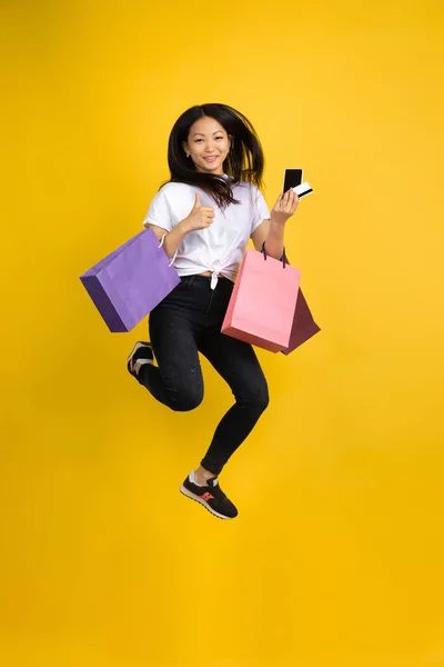 Portrait of young asian woman isolated on yellow studio background — Stock Photo, Image