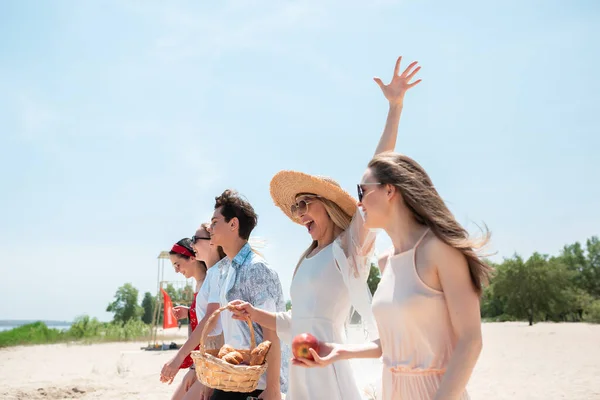 ビーチリゾートでの季節のごちそう。晴れた夏の日にビーチでお祝い、休息、楽しんでいる友人のグループ — ストック写真