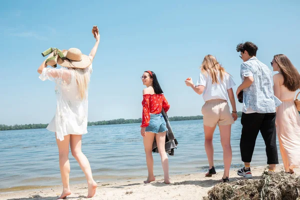 ビーチリゾートでの季節のごちそう。晴れた夏の日にビーチでお祝い、休息、楽しんでいる友人のグループ — ストック写真