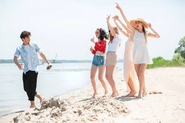 Festa stagionale al resort sulla spiaggia. Gruppo di amici che festeggiano, riposano, si divertono in spiaggia nella soleggiata giornata estiva — Foto Stock