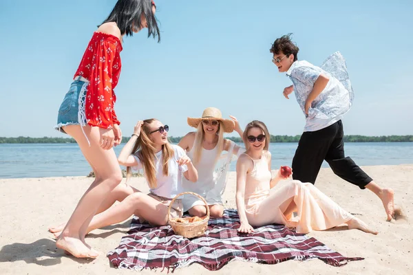Sezónní hostina v letovisku. Skupina přátel slaví, odpočívá, baví na pláži v slunném letním dni — Stock fotografie