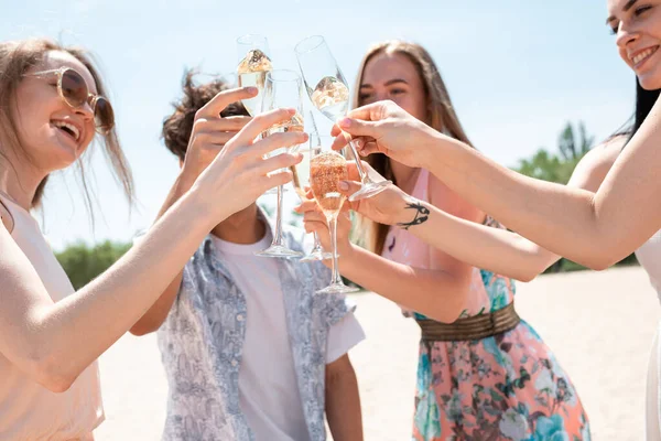 Seasonal feast at beach resort. Group of friends celebrating, resting, having fun on the beach in sunny summer day