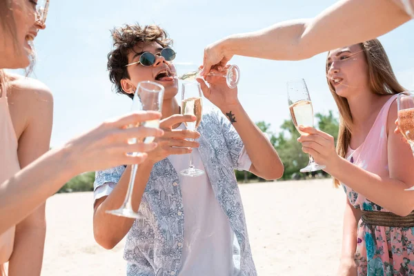 Fiesta estacional en el resort de playa. Grupo de amigos celebrando, descansando, divirtiéndose en la playa en el soleado día de verano —  Fotos de Stock