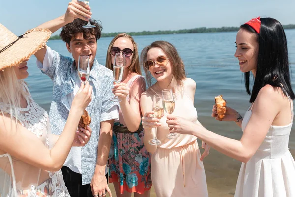 Plaj tatil köyünde mevsimlik ziyafet. Kutlama yapan, dinlenen, güneşli yaz gününde sahilde eğlenen bir grup arkadaş. — Stok fotoğraf