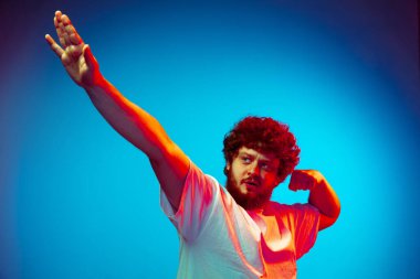 Beyaz adam portresi mavi stüdyo arka planında neon ışıkta izole edilmiş.